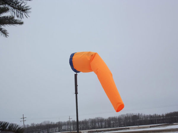 Orange windsock on snowy background